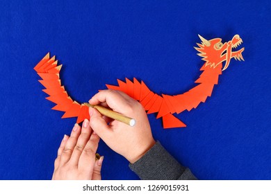 Diy Chinese Dragon On Blue Background. Gift Ideas, Decor Chinese New Year. Handmade Red Gold Lunar Dragon Lion From Modular Origami. Step By Step. The Process Of Crafts. Top View.