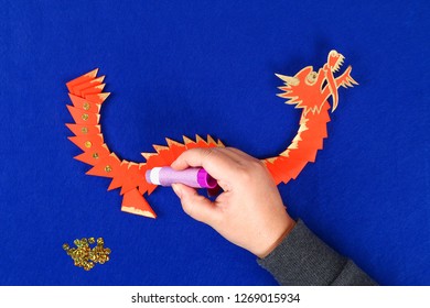 Diy Chinese Dragon On Blue Background. Gift Ideas, Decor Chinese New Year. Handmade Red Gold Lunar Dragon Lion From Modular Origami. Step By Step. The Process Of Crafts. Top View.