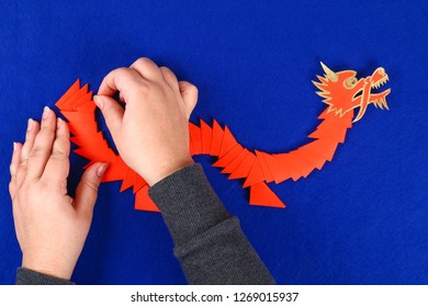 Diy Chinese Dragon On Blue Background. Gift Ideas, Decor Chinese New Year. Handmade Red Gold Lunar Dragon Lion From Modular Origami. Step By Step. The Process Of Crafts. Top View.