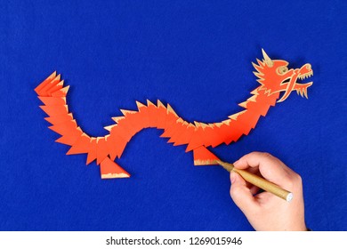 Diy Chinese Dragon On Blue Background. Gift Ideas, Decor Chinese New Year. Handmade Red Gold Lunar Dragon Lion From Modular Origami. Step By Step. The Process Of Crafts. Top View.