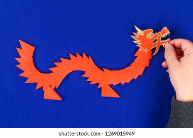 Diy Chinese Dragon On Blue Background. Gift Ideas, Decor Chinese New Year. Handmade Red Gold Lunar Dragon Lion From Modular Origami. Step By Step. The Process Of Crafts. Top View.