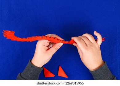 Diy Chinese Dragon On Blue Background. Gift Ideas, Decor Chinese New Year. Handmade Red Gold Lunar Dragon Lion From Modular Origami. Step By Step. The Process Of Crafts. Top View.