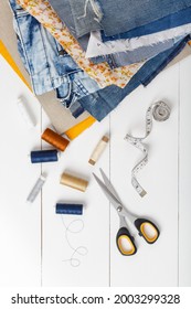 DIY Concept. Upcycle Old Denim Garbage. Recycling Blue Jeans Cut Pieces. Home Needlework. Sewing  Accessories, Threads,scissors On White Background. Circular Economy. Zero Waste Banner With Copy Space