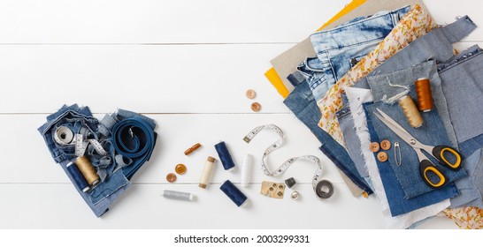 DIY Concept. Upcycle Old Denim Garbage. Recycling Blue Jeans Cut Pieces. Home Needlework. Sewing  Accessories, Threads,scissors On White Background. Circular Economy. Zero Waste Banner With Copy Space