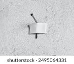 DIY do it yourself repairs, problems and failures. Expectation ve reality.  Nail mounted on a white wall with a white adhesive tape.