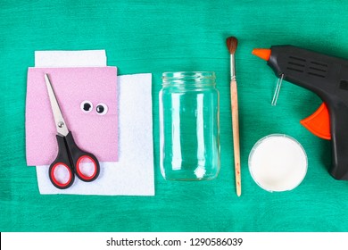 DIY Easter Vase Bunny From Glass Jar, Felt, Googly Eyes On A Green Background. Gift Ideas, Decor For Spring, Easter. Handmade. Step By Step. The Process Of Crafts. Top View. Childrens Easter Crafts.