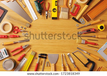 DIY and home improvement banner with work and construction tools on a wooden workbench top view, copy space at center