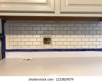 DIY Home Project Installing White Tiles, Grout, And Electrical Wires In Kitchen Backsplash