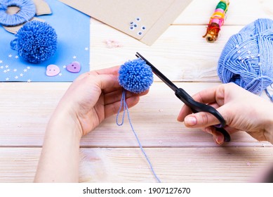 Wie man aus den Pom-Poms ein Hasen für die Osterdekoration macht. Kinderkunst-Projekt. DIY-Konzept. Die Hände machen aus einem Schlafanzug ein blaues Osterhase. Schritt für Schritt Fotoanleitung.