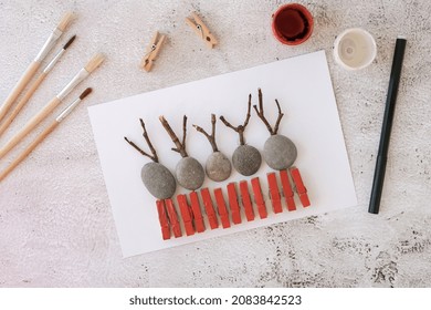 Diy Merry Christmas deer on greeting card postcard made of pebbles, sea stones, clothespins and branches on white background. Natural Eco style diy. Gift idea. Step by step. Top view. Process kid  - Powered by Shutterstock