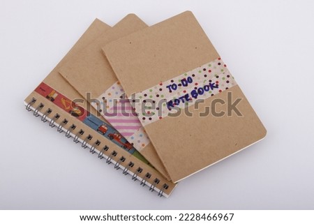 DIY plain brown notebooks with washi tape on cover against a white background