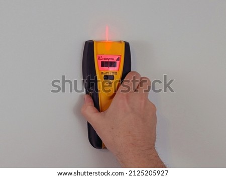 DIY using electronic stud finder to search wall for studs, finding wall stud for anchors do it yourself project 
