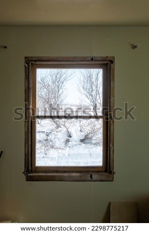 DIY window insert install in old house with wintery snow and trees in view