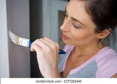 DIY Woman Decorating At Home Painting Wall With Paintbrush For Home Improvement