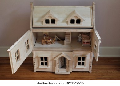 A DIY Wooden Doll House In A Child's Room To Play Pretend. The Doors Are Open On The Second Floor And The Dolls Room Is Shown With Miniature Furniture. 