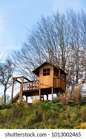 DIY Wooden Playhouse For Children With Swing And Slide On A Hillside In A Sunny Day