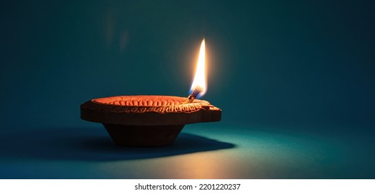 Diya oil lamp lit. Diwali, Deepavali Hindu Festival of lights celebration, blue background. Indian holiday template
 - Powered by Shutterstock