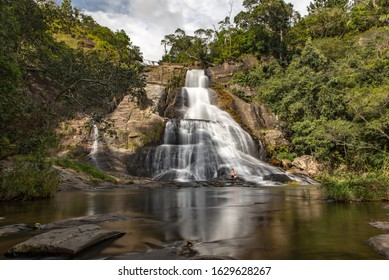 Diyaluma, Haputale, Sri Lanka. 2019 Nov 22:  Young tourist men in the Sunny day in the Tropical waterfall falls from the mountain cliff to the jungle, serene landscape of Diyaluma falls.