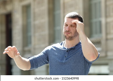 Dizzy Adult Man Suffering Headache Trying To Stay Standing In The Street