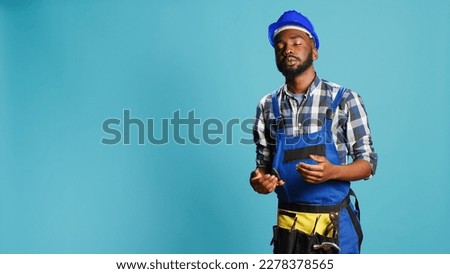Dizzy construction worker feeling light headed in studio, almost fainting and having cartoonish stars above his head. Male contractor with hardhat being disoriented and unsteady, looney tunes.