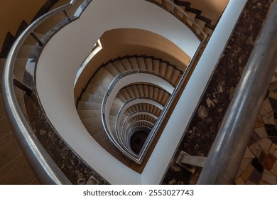 Dizzying spiral staircase view captures elegant curves and architectural beauty within building. - Powered by Shutterstock