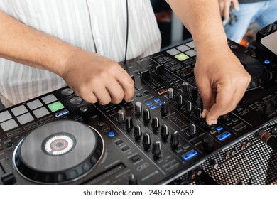 DJ adjusting mixer controls during live performance. Professional equipment at a live event. Electronic concept - Powered by Shutterstock