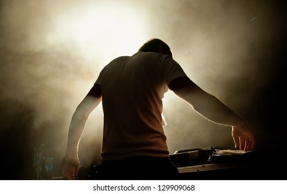 the DJ behind work in night club