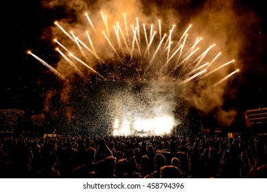 DJ Concert Festival with Special Effects Fireworks over the Silhouette Crowd Backlit
