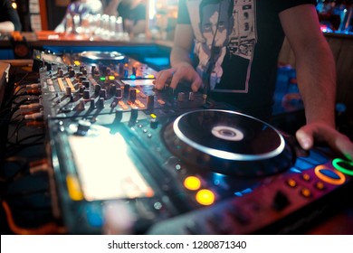 DJ console cd mp4 deejay mixing desk Ibiza house music party in nightclub with colored disco lights.