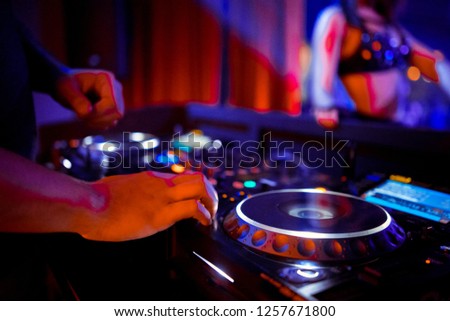 DJ console cd mp4 deejay mixing desk Ibiza house music party in nightclub with colored disco lights.