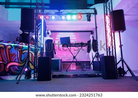 Dj controller on stage for discotheque in empty nightclub with no people. Electronic musician console equipment, loudspeakers and spotlights for live music concert in dark club.