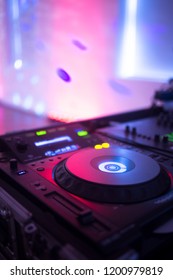 DJ deejay mixing desk equipment in wedding receoption party disco with color discotheque lights.
