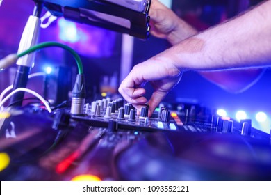 Dj djing in a nightclub with the clubs lights