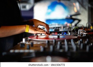 DJ Girl Playing Music In Night Club With Retro Turntables,vinyl Records.Female Disc Jockey Scratches Record On Turn Table Player Device On Concert Stage In Nightclub.Professional Djs Setup On Scene