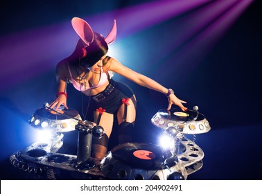 DJ Girl In Sexy Pink Bunny Suit Playing On Vinyl