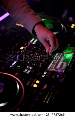 DJ hand adjusting an audio controller during a performance, highlighting technology, creativity and the vibe of electronic music. Ideal for event, sound and entertainment themes.