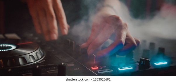 DJ Hands creating and regulating music on dj console mixer in concert nightclub stage