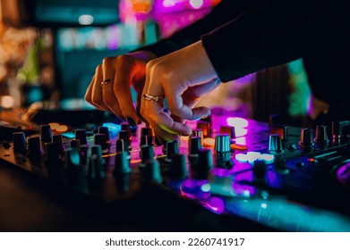 DJ Hands creating and regulating music on dj console mixer in concert nightclub stage - Shutterstock ID 2260741917