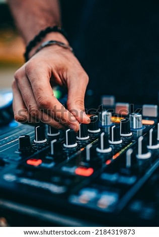 DJ Hands creating and regulating music on dj console mixer in concert outdoor