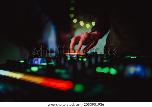 DJ Hands creating and regulating music on dj\
console mixer in concert\
nightclub