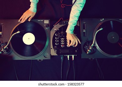 Dj hands on equipment deck and mixer with vinyl record at party - Shutterstock ID 158323577
