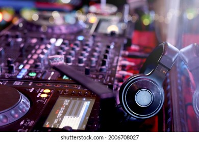 DJ headphones on controller turntable console mixing desk at stage in the night club, music beach party festiva and nightlife concept.