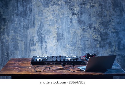 Dj Mixer With Headphones And Laptop On Wooden Table Close-up.