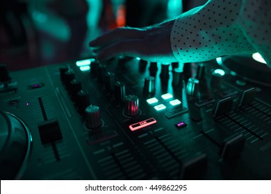 Dj mixes the track in nightclub at party with dancing people on blur background - Shutterstock ID 449862295