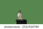 DJ mixing music on a turntable in a studio on a green screen background