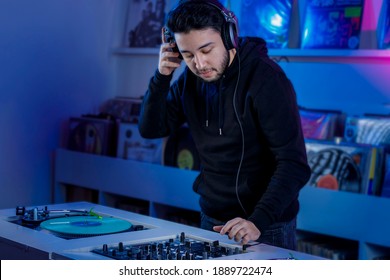 dj mixing music in a vinyl record store using a turntable and audio mixer.