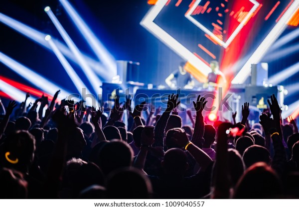 Dj party at nightclub. Crowd rave at the stage\
background. Stranger Dj\'s 