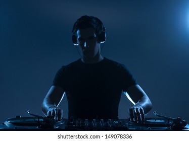 DJ Playing Music. Confident Young DJ Spinning On Turntable While Standing Isolated