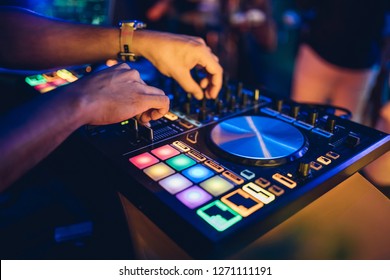 DJ Plays Live Set And Mixing Music On Turntable Console At Stage In The Night Club. Disc Jokey Hands On A Sound Mixer Station At Club Party. DJ Mixer Controller Panel For Playing Music And Partying.