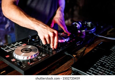 DJ plays live set and mixing music on turntable console at stage in the night club. Disc Jokey Hands on a sound mixer station at club party. DJ mixer controller panel for playing music and partying. - Shutterstock ID 1502720459